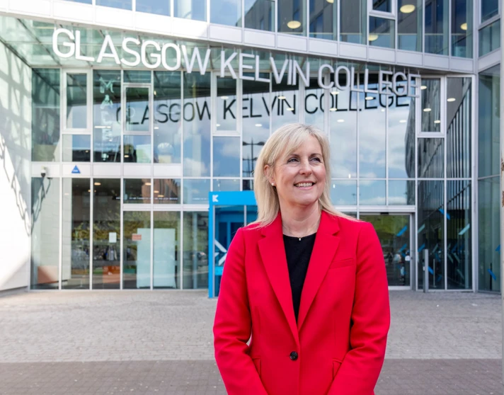 Joanna Campbell, Principal of Glasgow Kelvin College, smiling outside the college’s main entrance in a bright red blazer Joanna Campbell, Principal of Glasgow Kelvin College, smiling outside the college’s main entrance in a bright red blazer